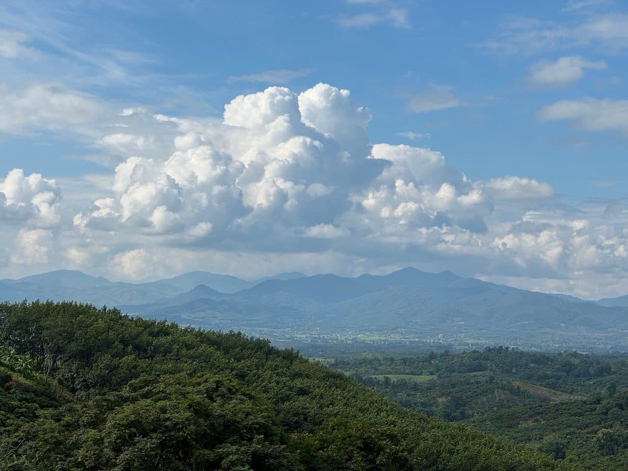 Cumulus piled over the mountains beyond the valley floor
