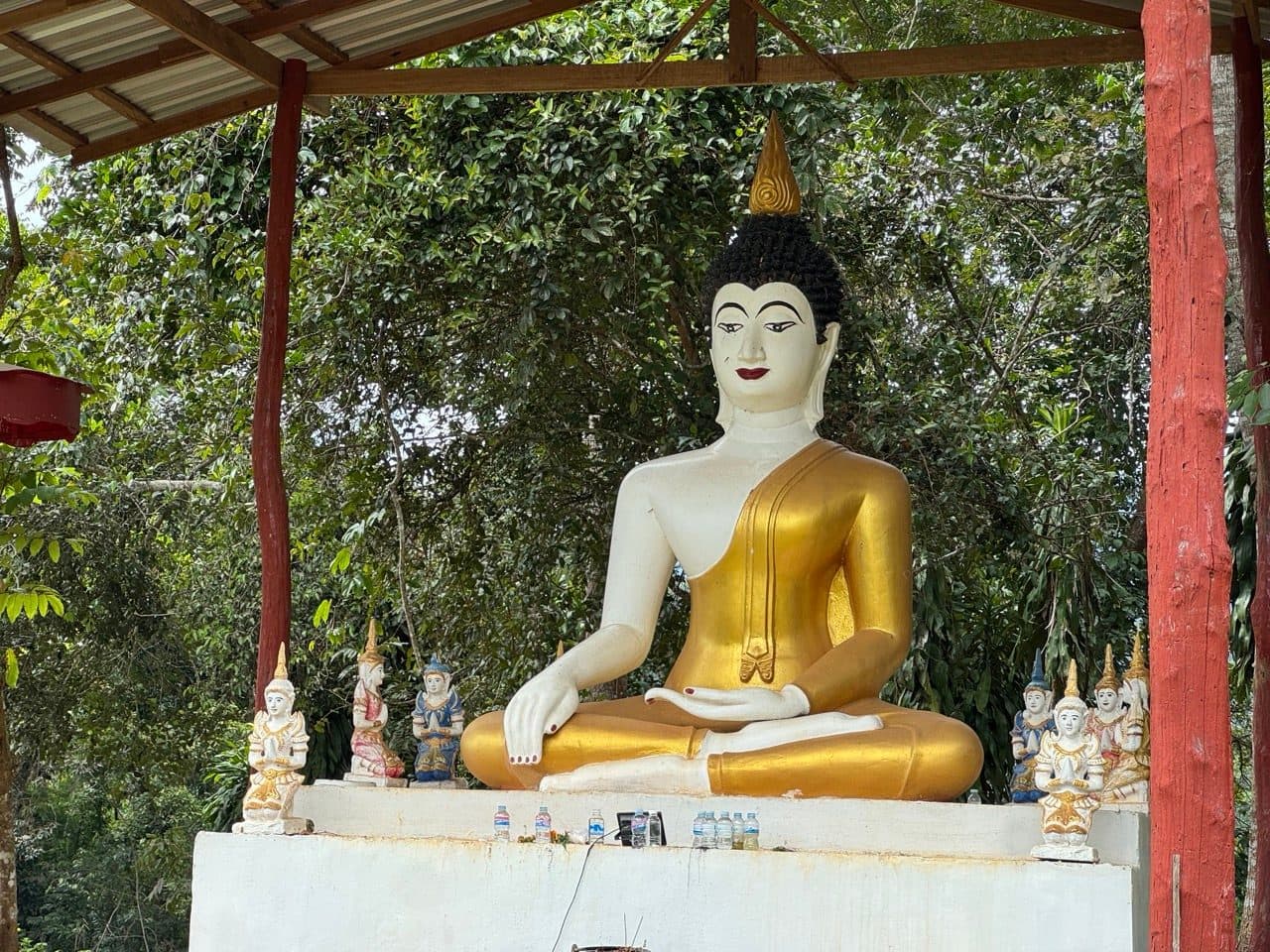 Seated Buddha and attendant figures under an open shelter